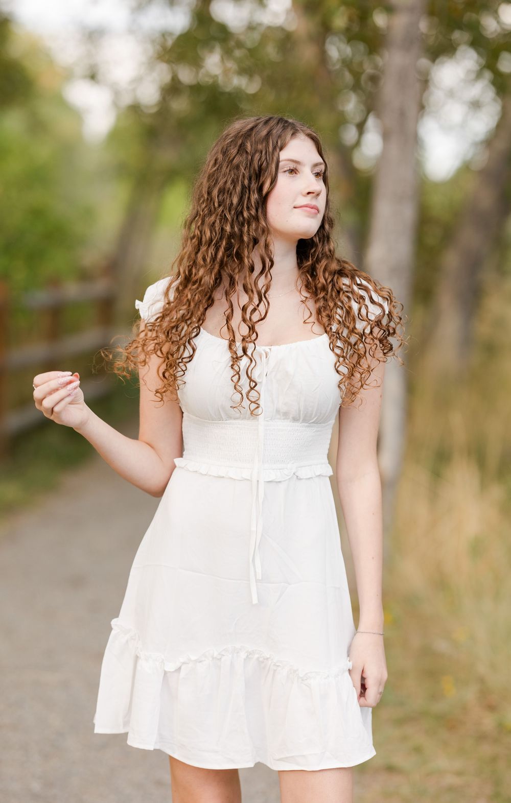 A series of outdoor portraits showing someone in a flowing white sundress twirling in a natural setting.