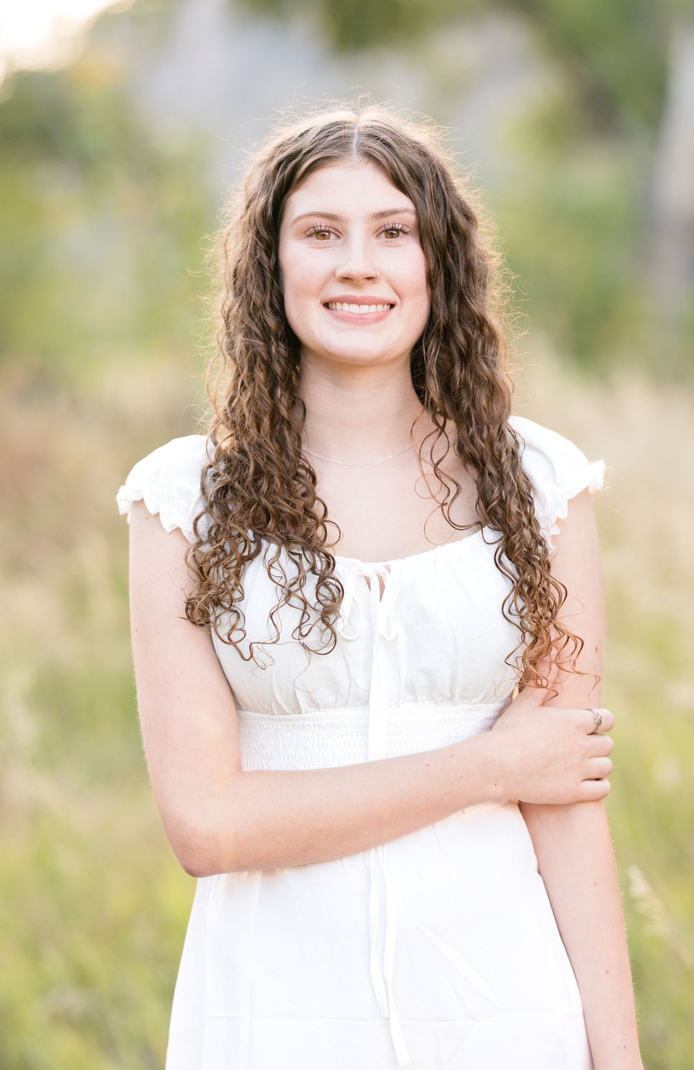 A series of outdoor portraits showing someone in a white dress with curly hair against a soft natural background.
