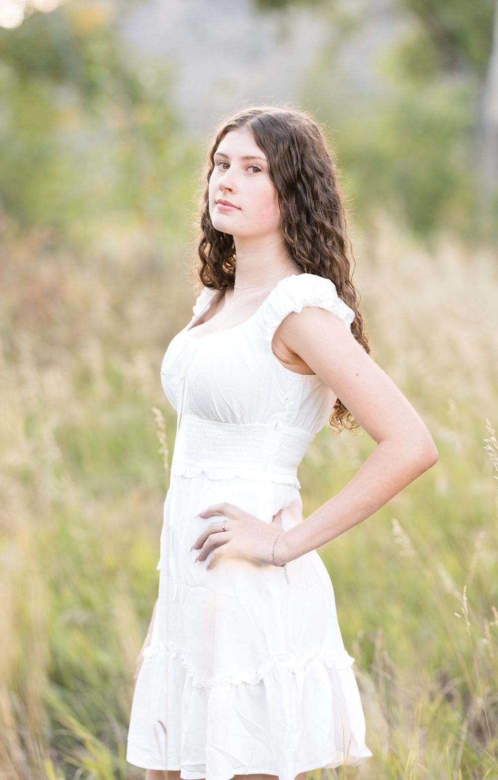 A collage of outdoor portraits showing someone in a flowing white dress posing gracefully in a sunlit field.