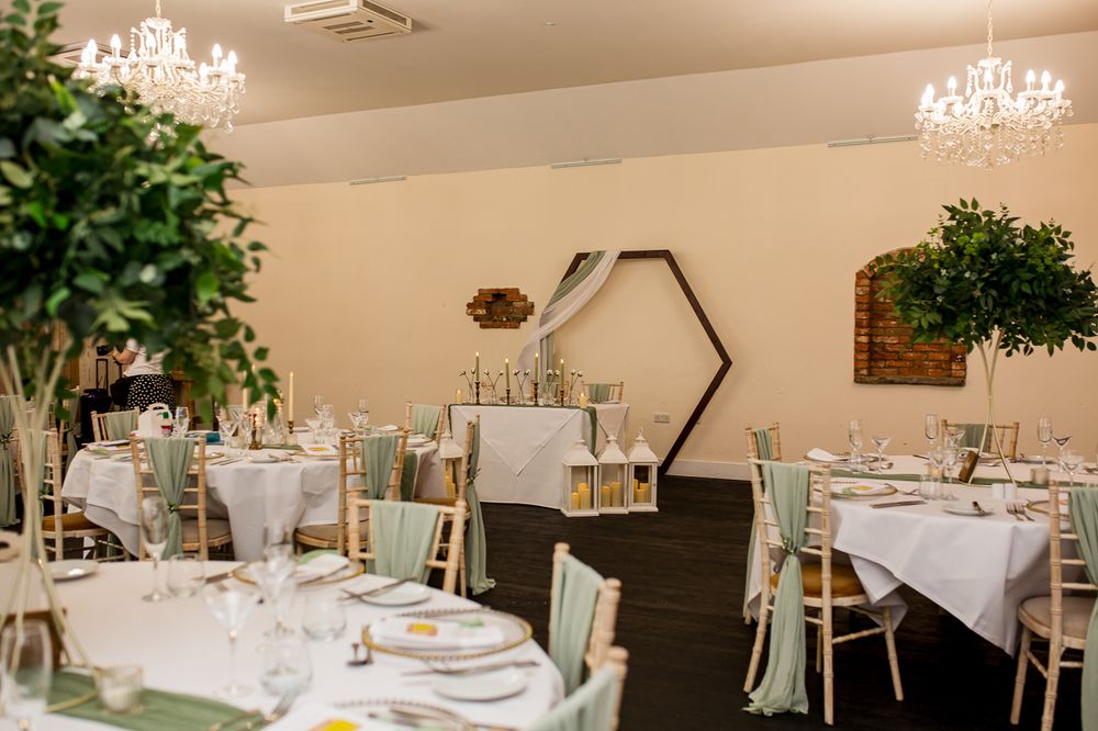 Elegant wedding reception venue with crystal chandeliers and white tablecloths set for a formal dining experience.