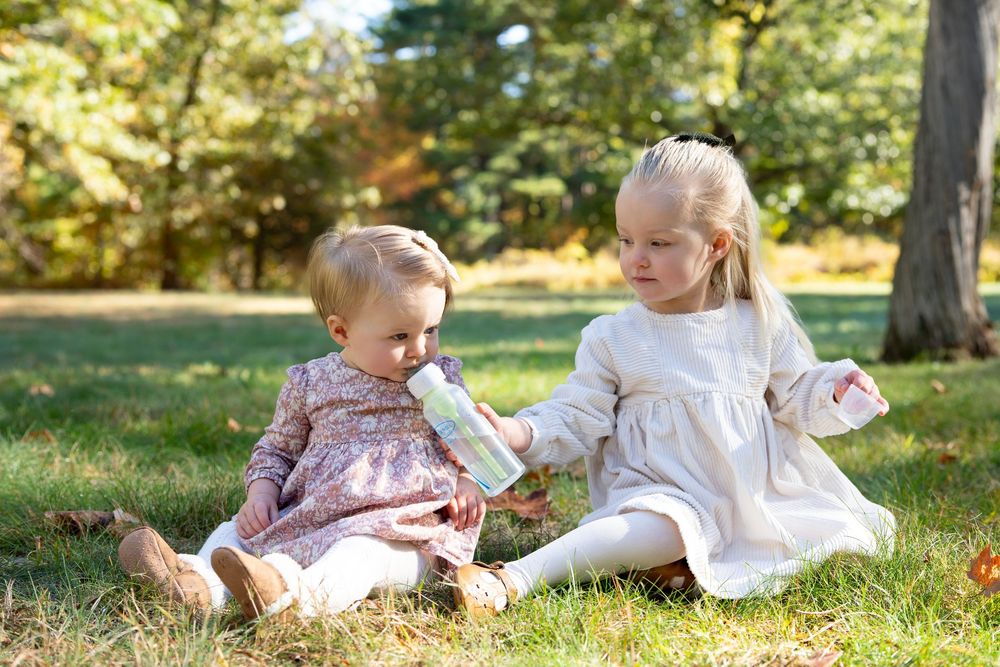 Sisters play at the Wayside Inn Grist Mill in Sudbury, MA. Family Portraits in the Greater Boston Area by Leah Ramuglia Photography.
