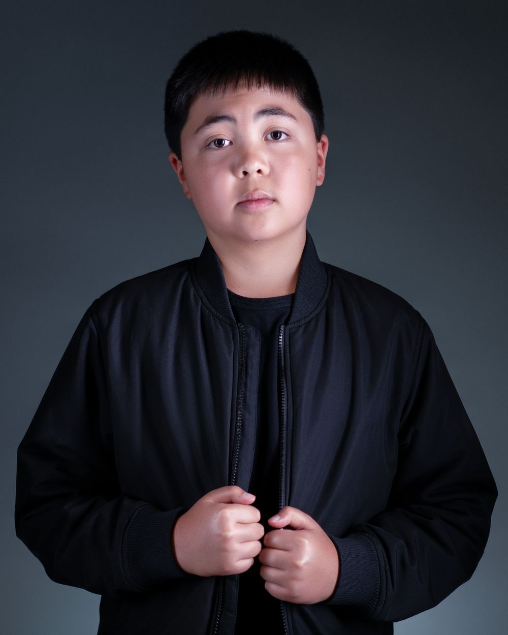 A figure in a black sweater poses against a dark background in a sequence of four dramatic studio shots.