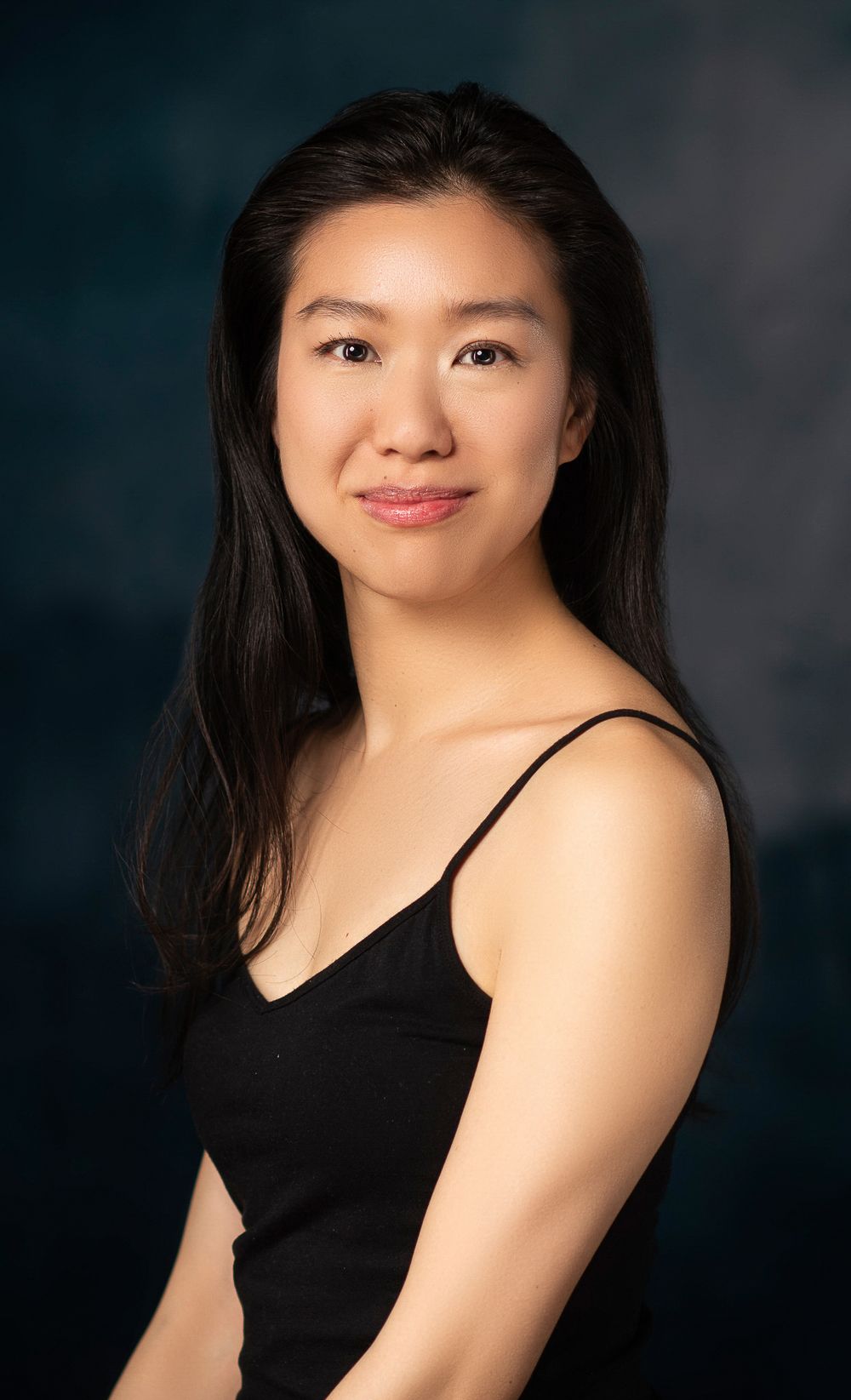 Professional studio portrait series against dark background featuring poses in a sleeveless black top.
