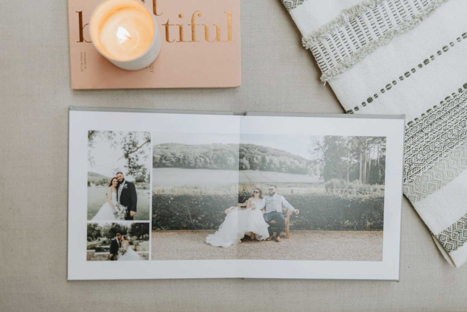 A collection of black and white and sepia toned wedding photographs arranged with candles on a light colored surface.