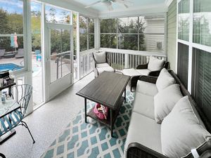 Bright sunroom with comfortable seating and coastal decor featuring blue accents.