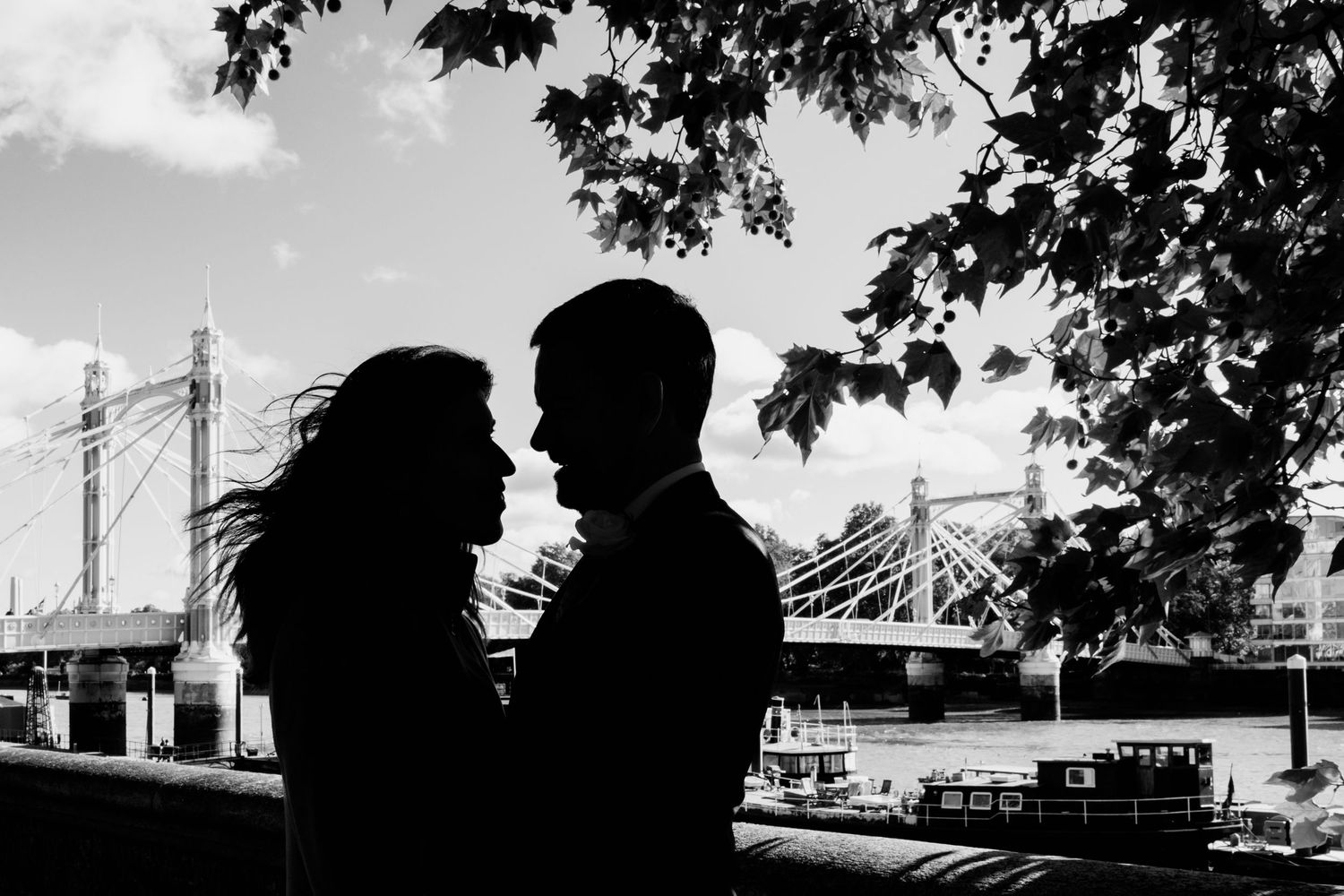 Silhouettes of trees and buildings create a dramatic black and white panoramic skyline against a bright sky.