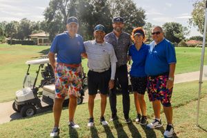 Group of golfers gathered on a sunny golf course for a tournament or event.