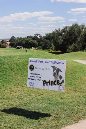 Golf course signage for the Annual Fore Paws Golf Classic event with sponsor markers.