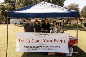 White event tent with Carrabba's catering banner displayed at outdoor golf event.