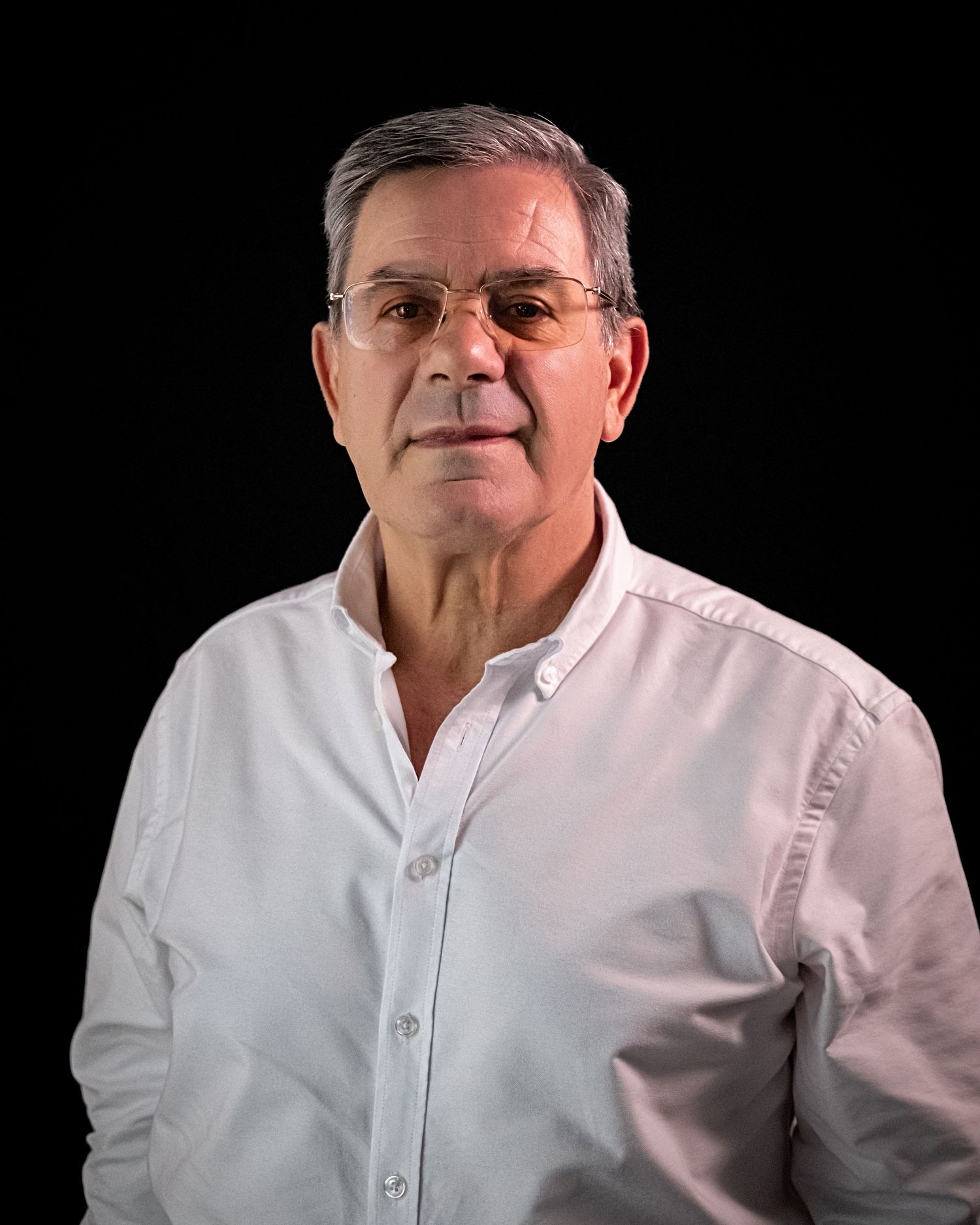 Professional headshots of a person in a white dress shirt against a dark backdrop.
