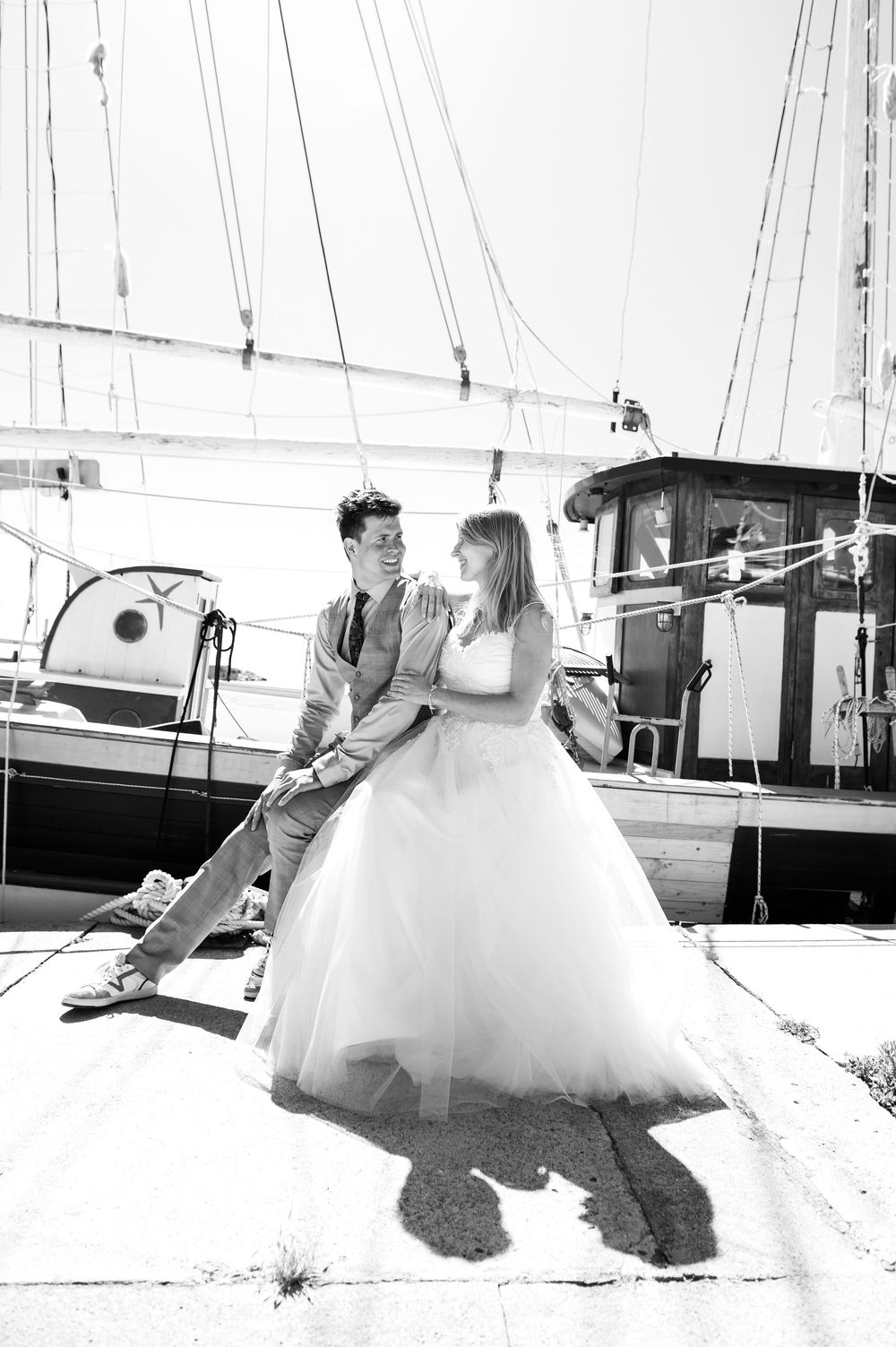 A romantic black and white photo sequence captured at a marina with sailboats.
