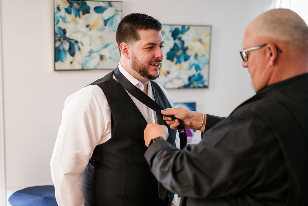 A series of four photos showing a tie being adjusted during a formal occasion.