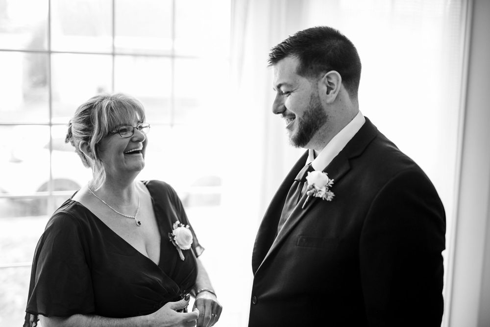 A black and white wedding photo collage showing candid moments of a couple laughing and embracing.