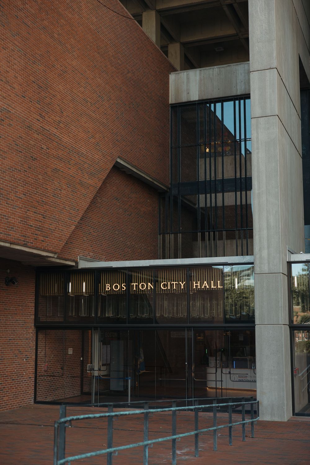 Modern brick facade of Boston City Hall with concrete columns and entrance signage.