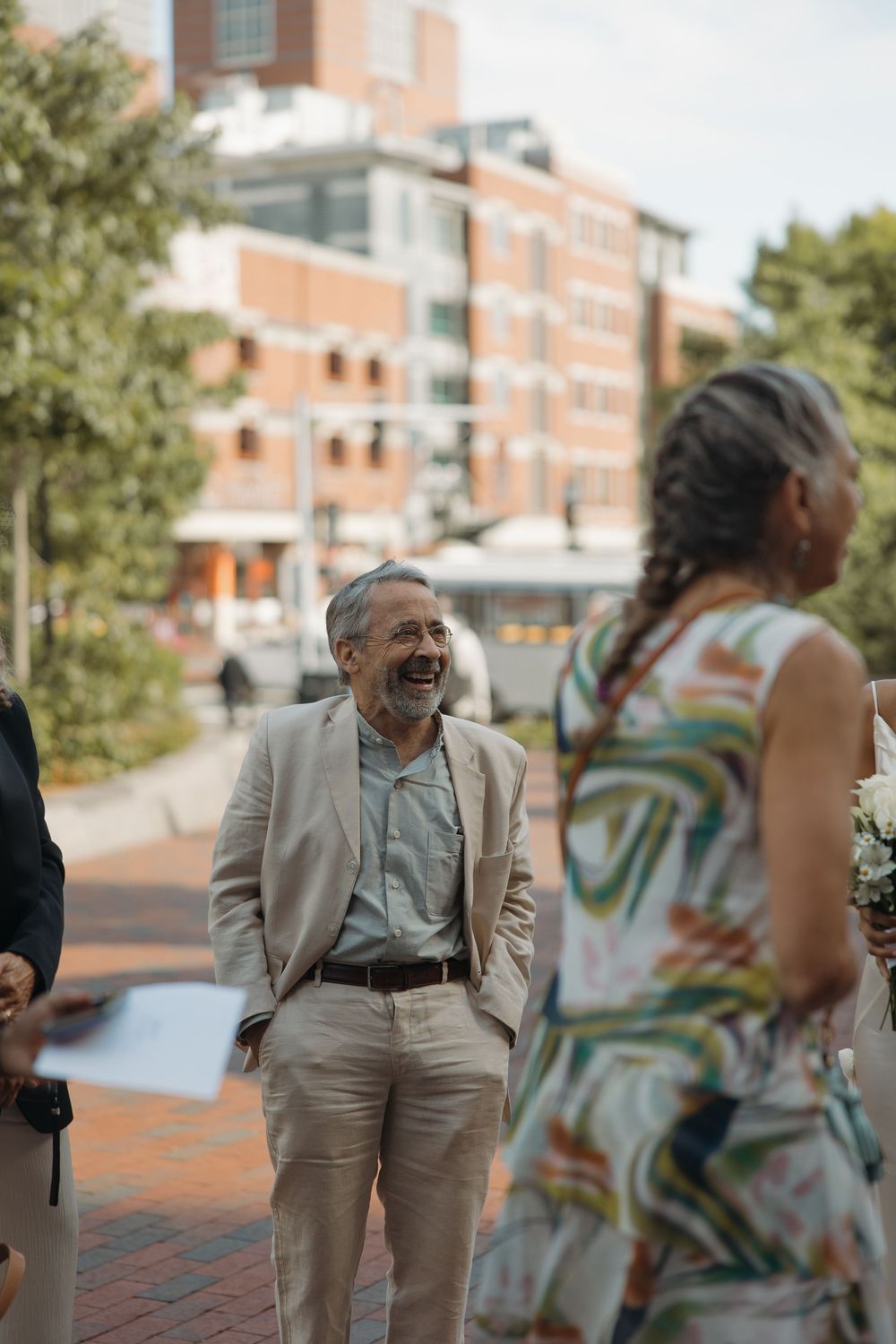 Outdoor celebration on brick pavement with guests in formal attire.
