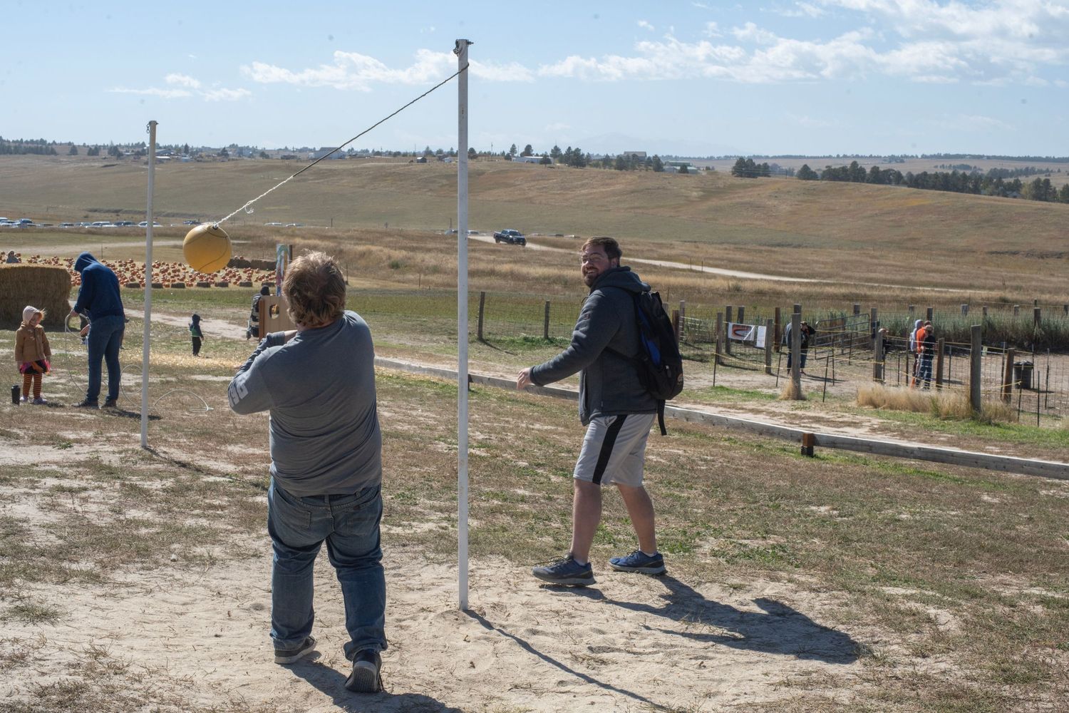 A group of people practicing clay pigeon shooting at an outdoor range in an open field.