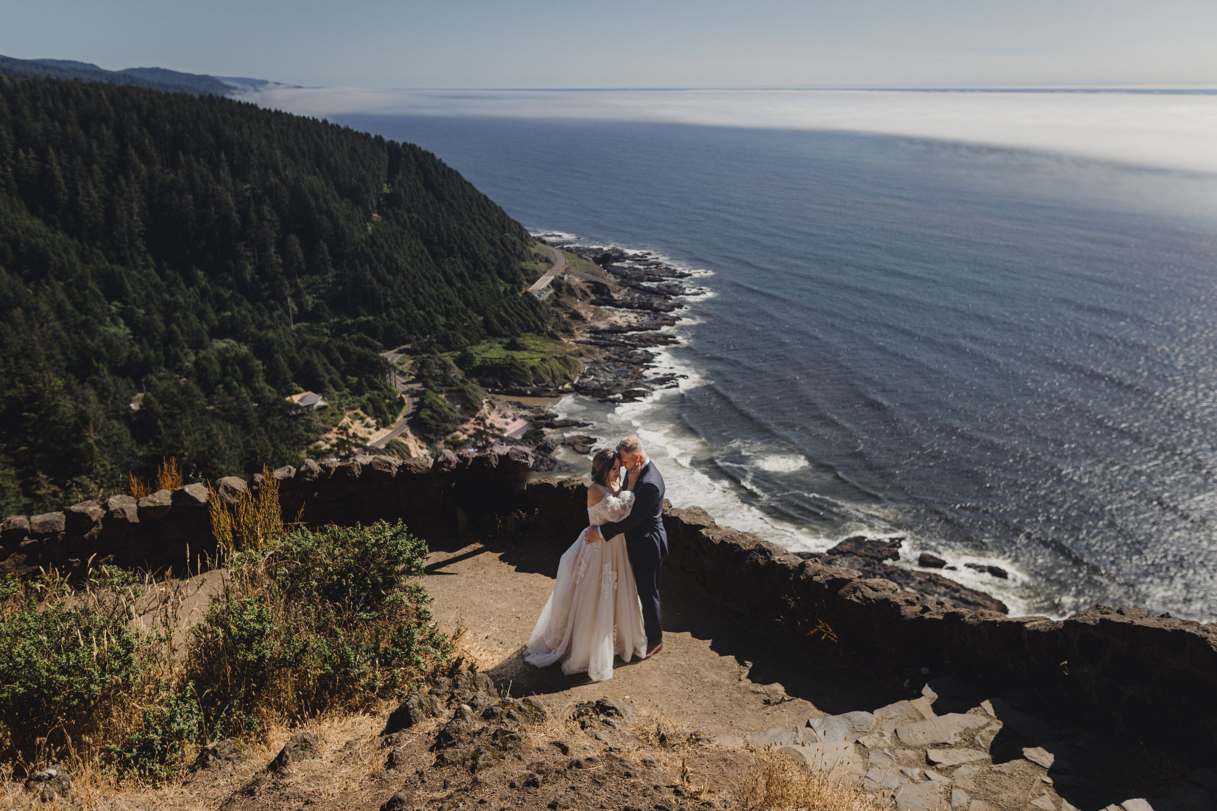 Panoramic coastal views along the rugged Oregon coastline with cliffs, beaches, and dense forest meeting the Pacific Ocean.