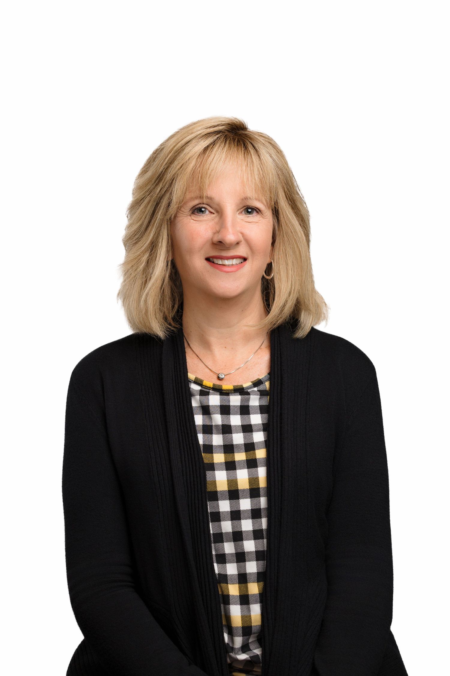 Professional headshot portrait of someone wearing a black blazer and checkered top with blonde hair against white background.
