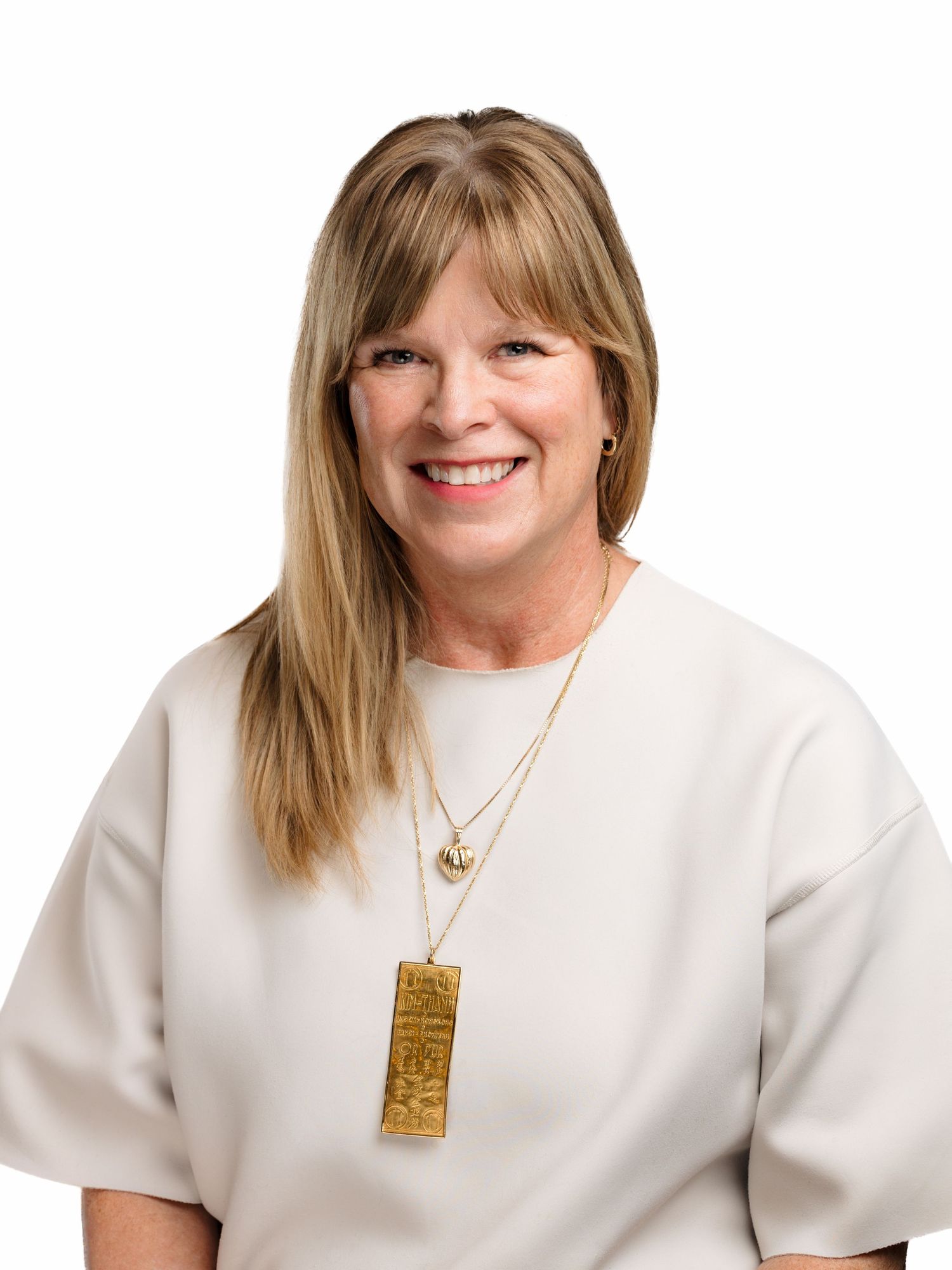 Three headshots of a person in a white shirt wearing a gold pendant necklace against a light background.