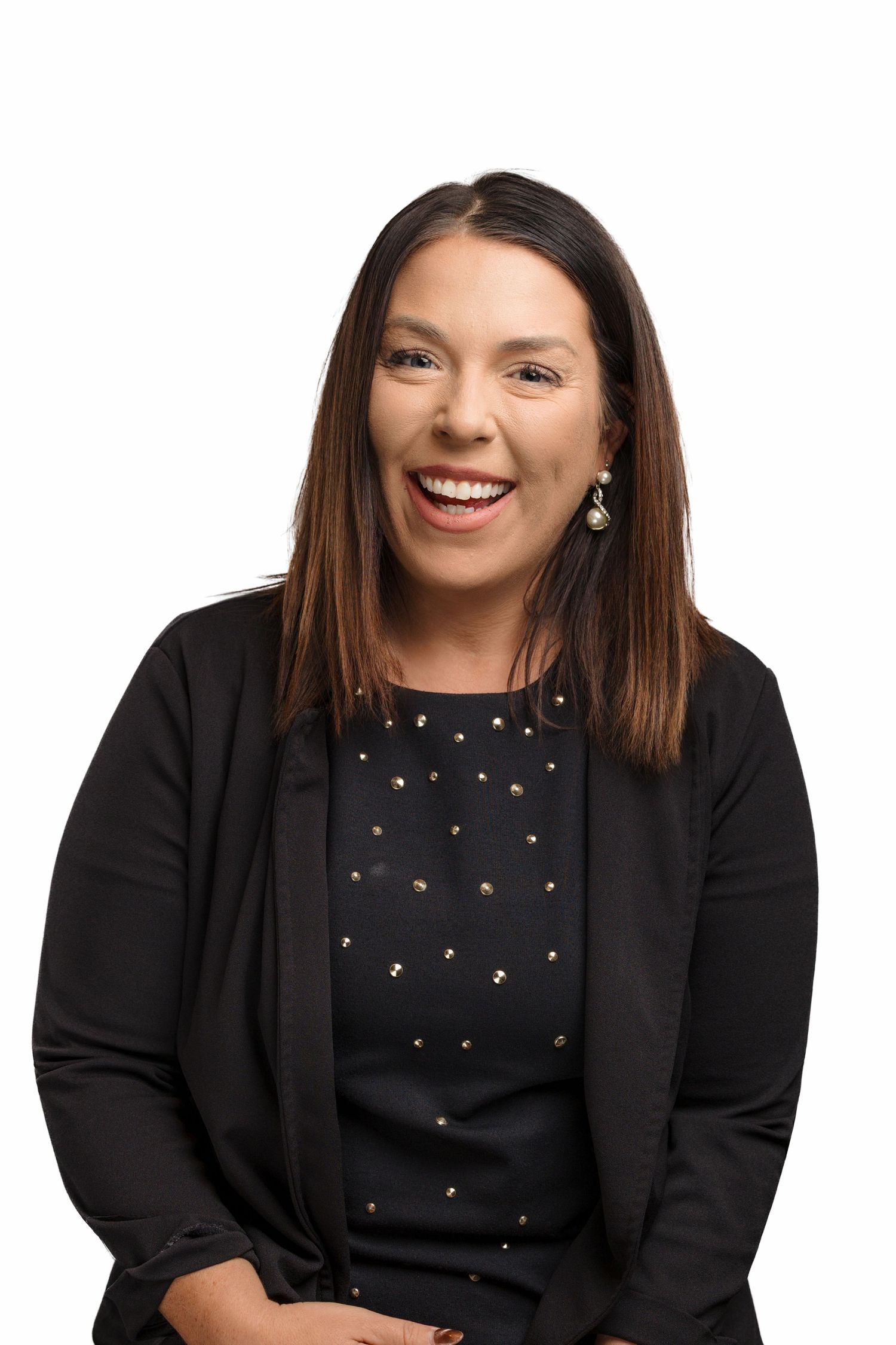 Professional headshot of someone wearing a black cardigan and polka dot top while smiling warmly at the camera.