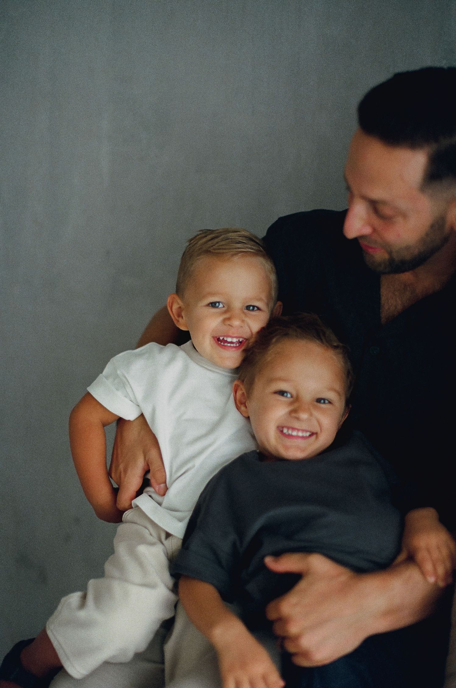 A series of candid family photos showing joyful moments between parent and child against a gray backdrop.