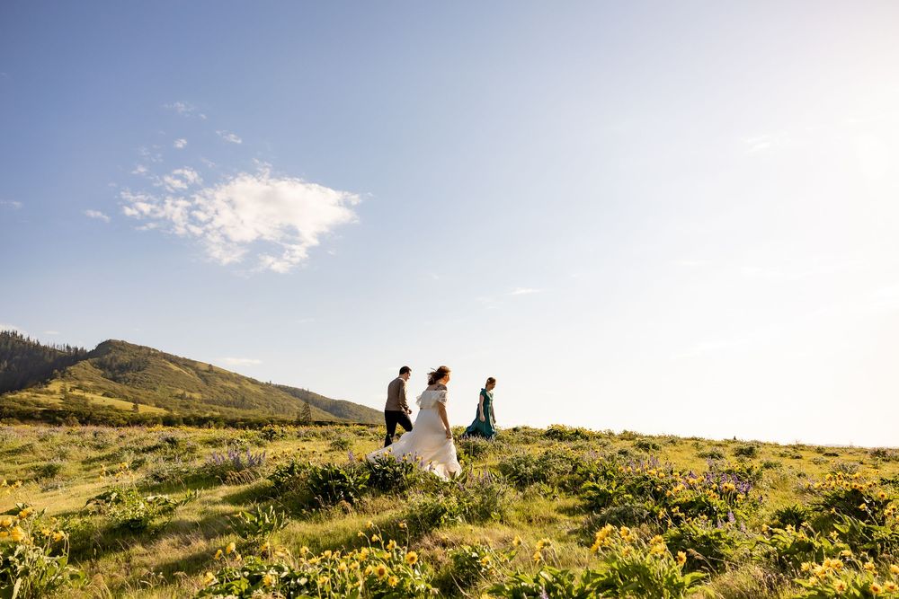 Silhouettes of hikers exploring a mountainside trail during golden hour.
