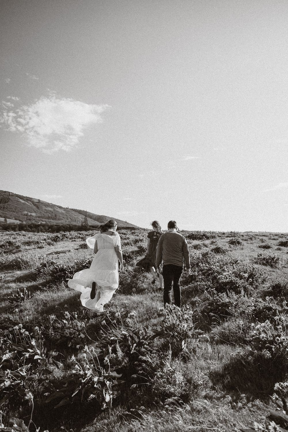 People walking together through a scenic hillside landscape under bright skies.
