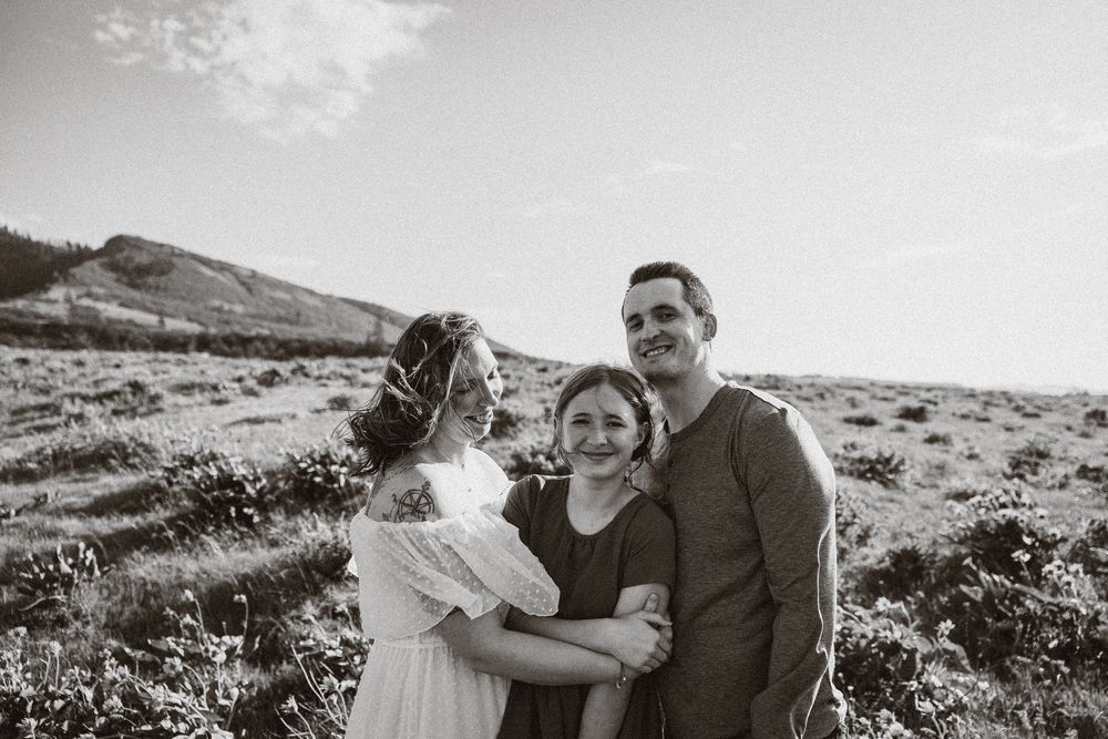 A candid black and white photo of people sharing a happy moment on a coastal hillside.