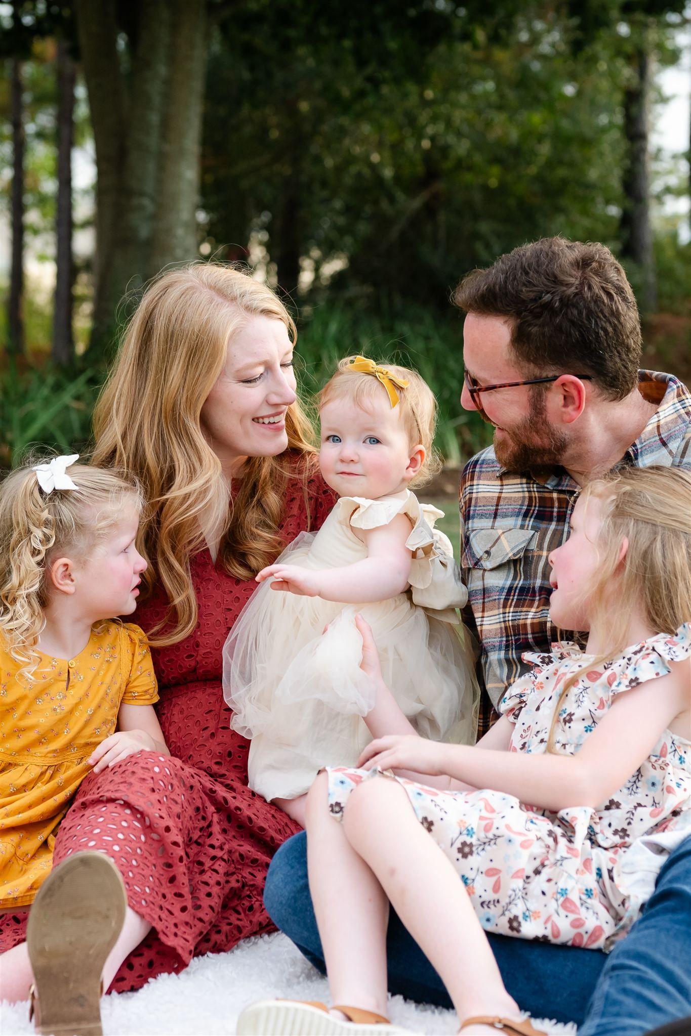 Family enjoying a relaxed outdoor picnic together on a sunny day in a park setting.