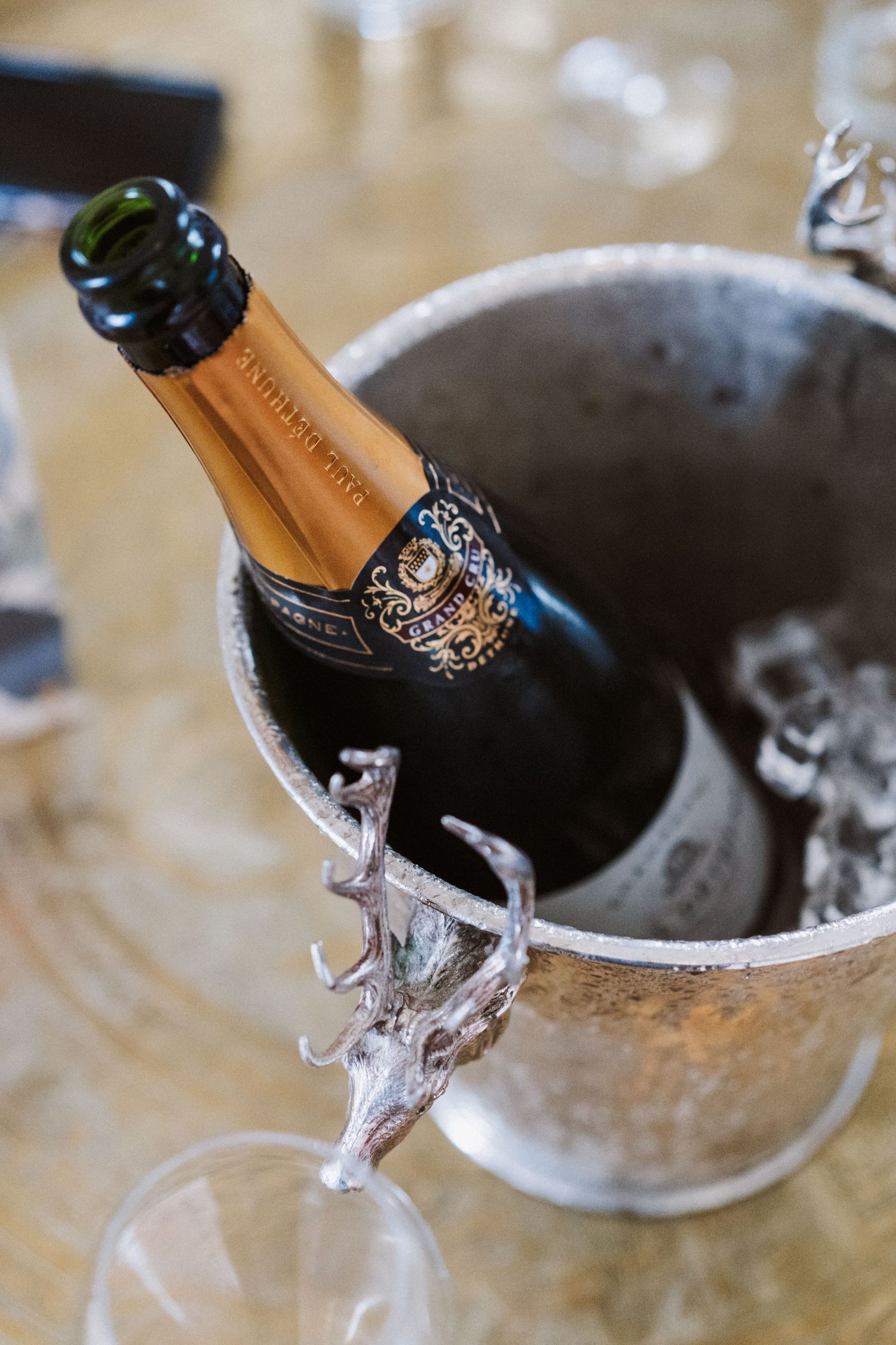 A sequence showing a champagne bottle being opened in a silver ice bucket, with bubbles fizzing over the top.