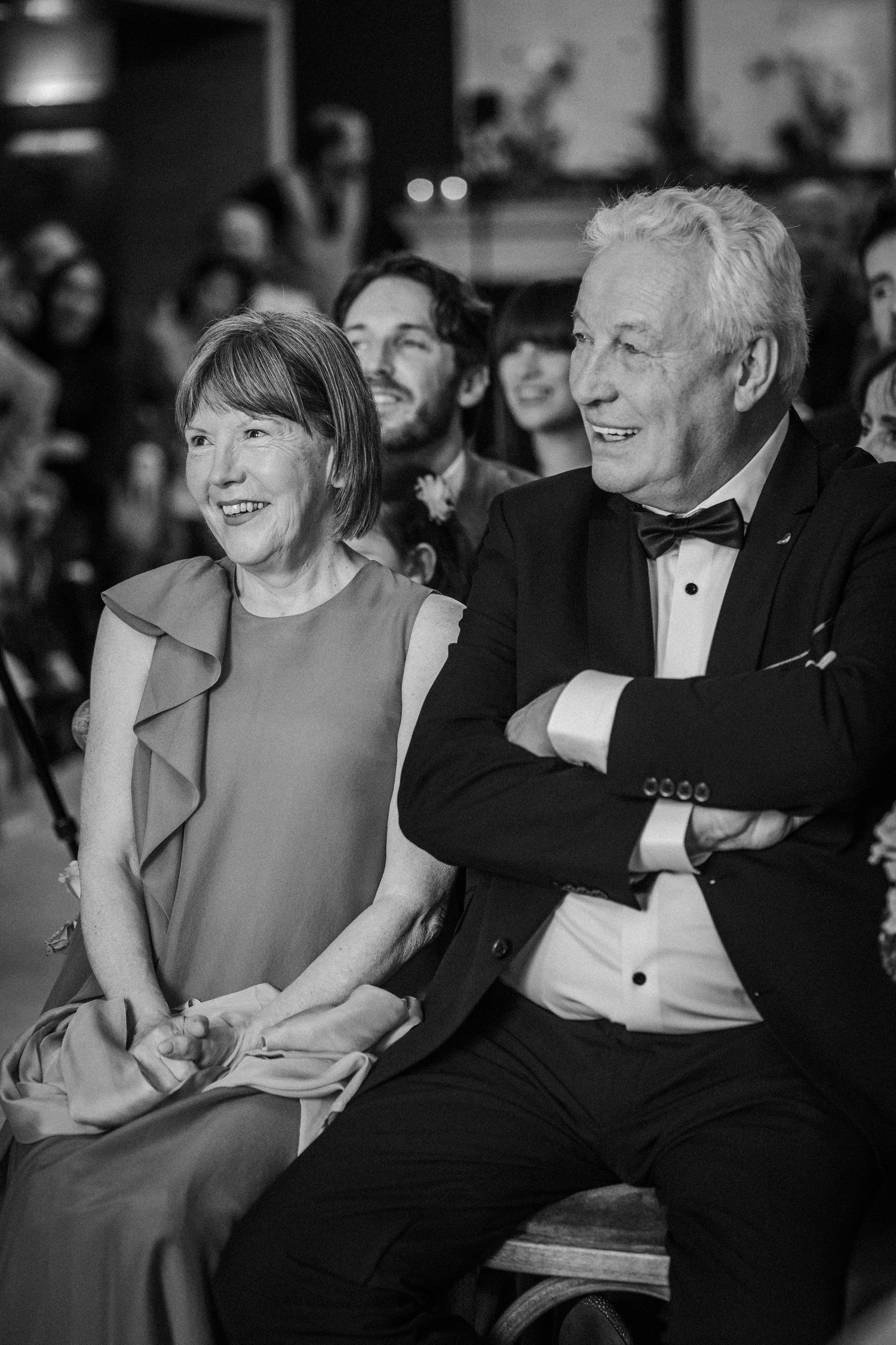 Black and white photo of wedding guests enjoying moments during the reception.