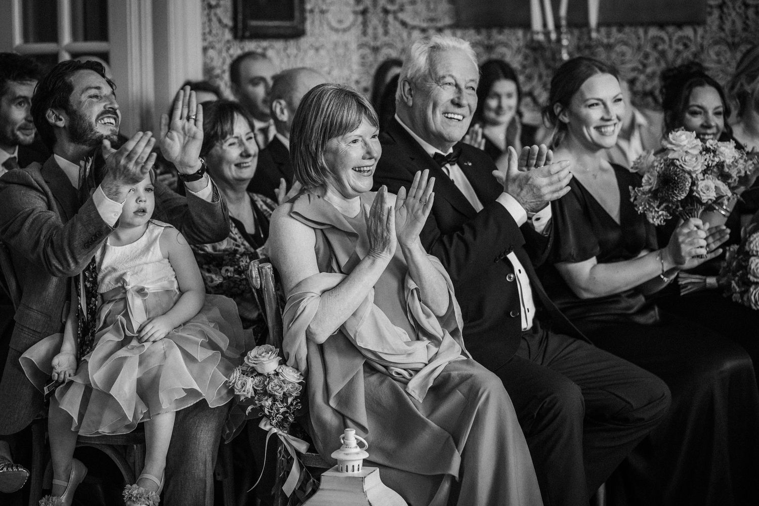 Black and white photos of wedding guests laughing and enjoying celebration moments.