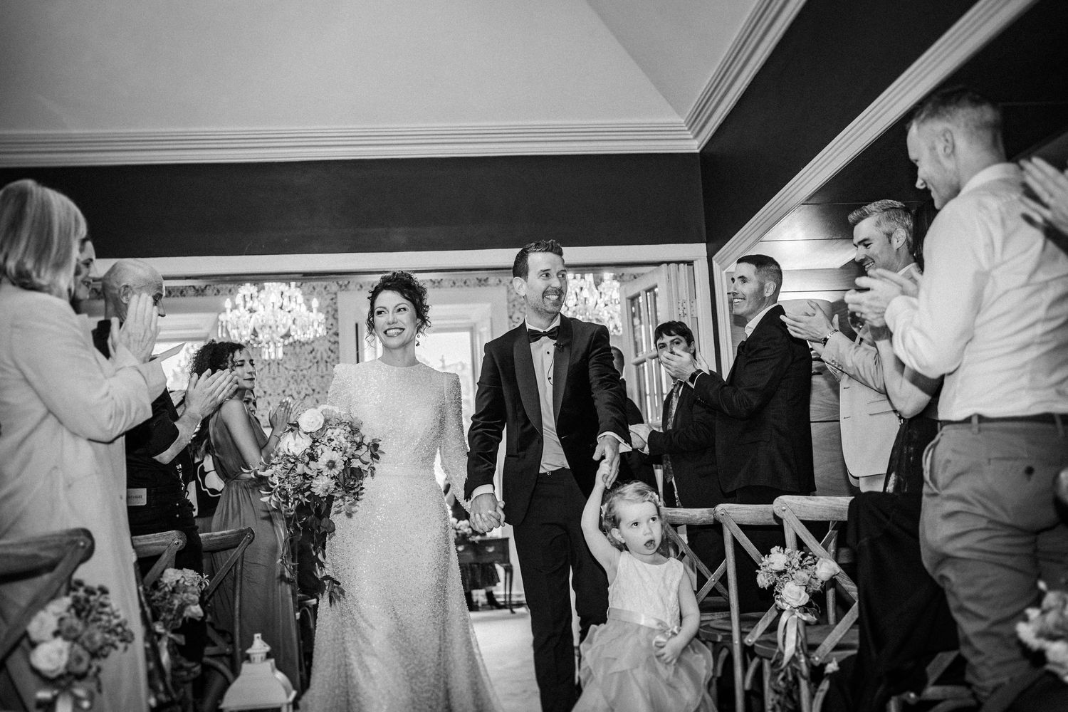 Wedding reception candid shots showing guests dancing and celebrating in black and white.