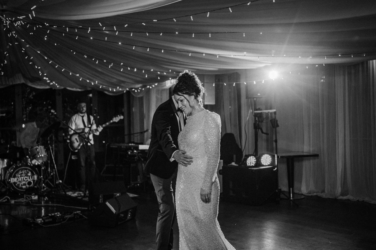 Black and white wedding reception photos showing dancing and celebration under string lights in an elegant venue.