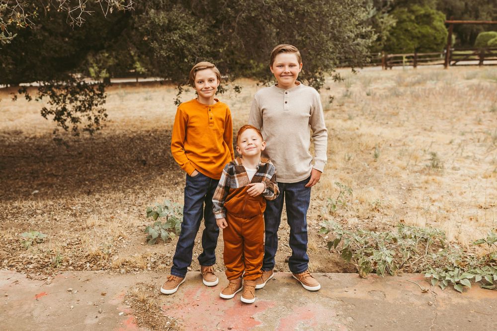 Family members sitting together on ground during golden hour photo session.