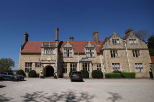 Panoramic exterior view of Rutland Hall Hotel showing Tudor-style architecture under blue sky.