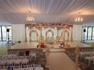 A collage of elegant white wedding reception halls with chandeliers, draped fabric ceilings, and chiavari chairs.