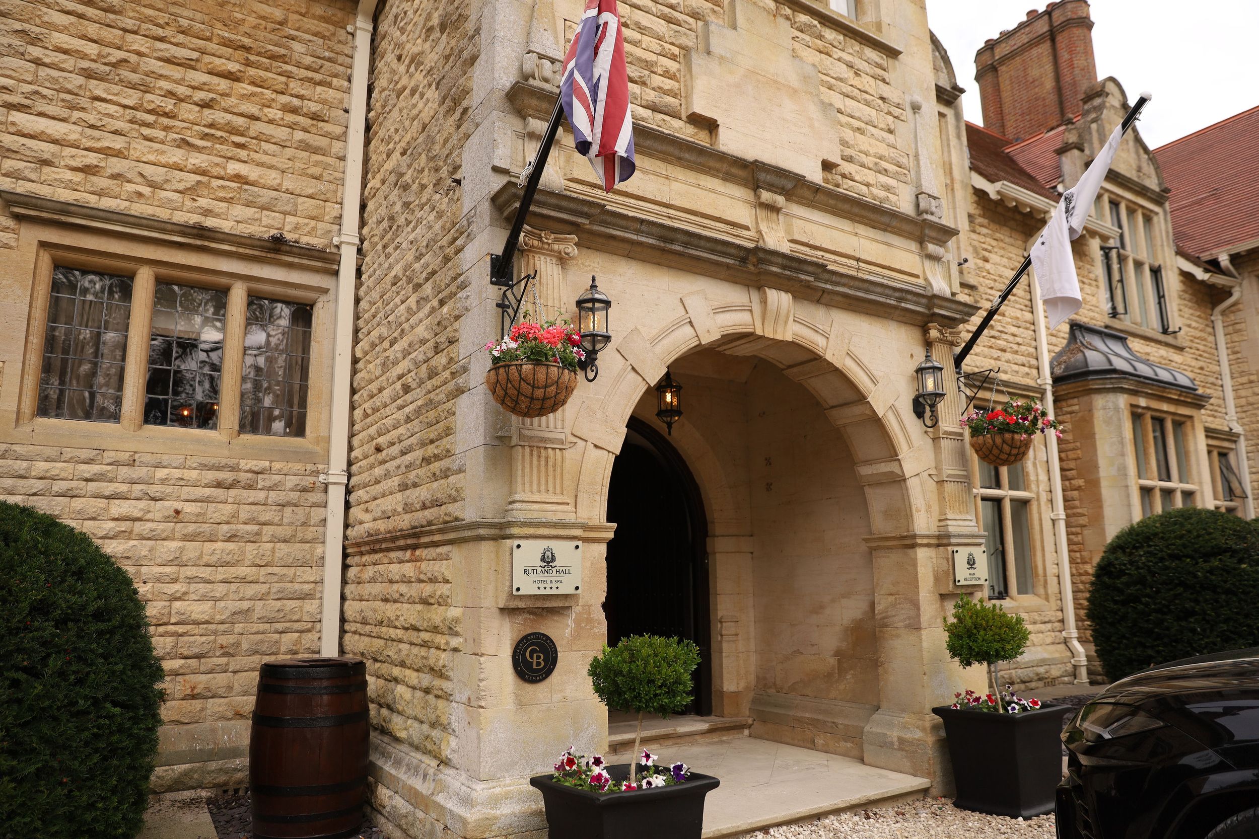 Elegant stone facade of a historic hotel building with ornate architectural details and British flag.