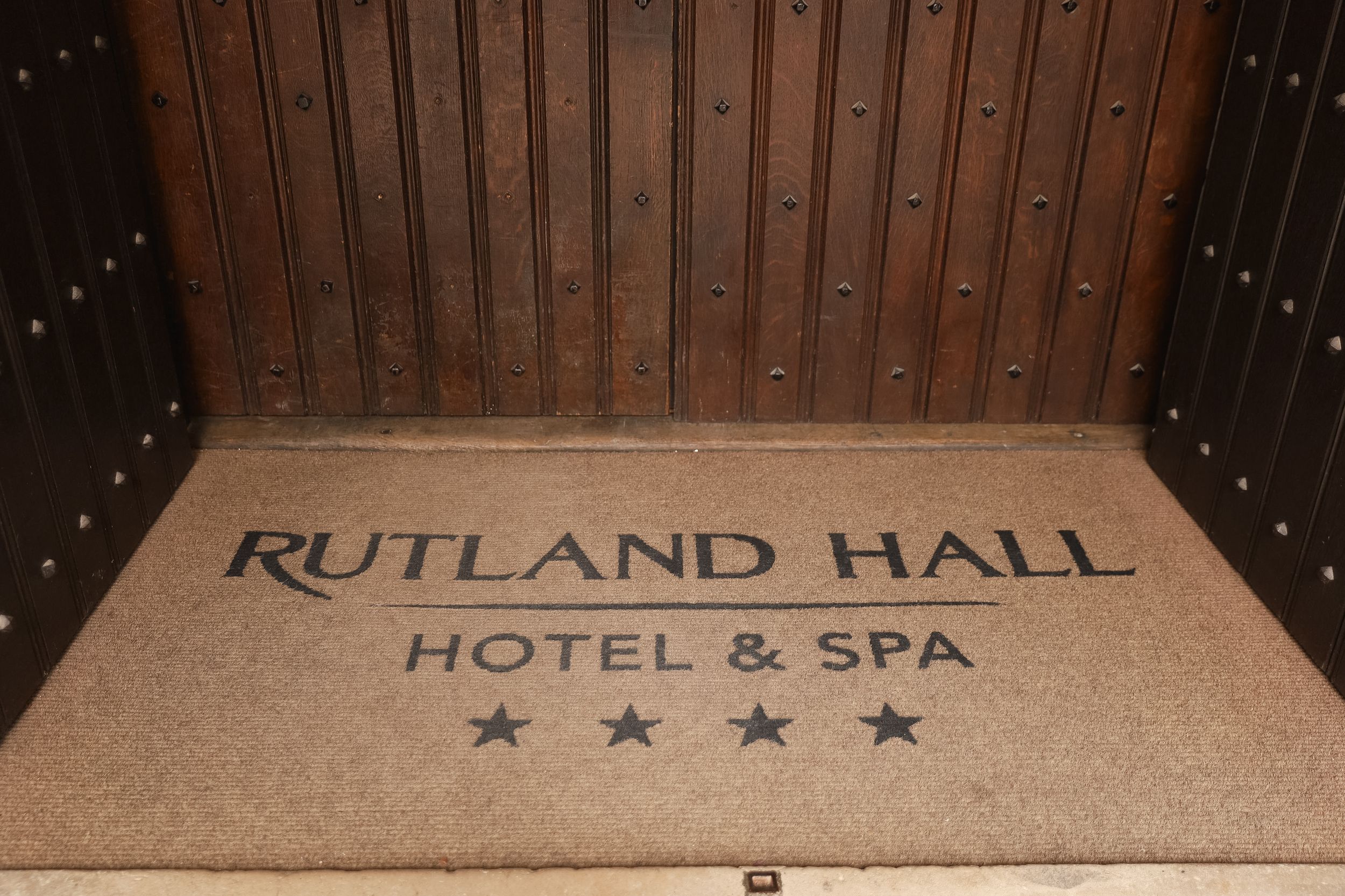 Elegant wooden paneled ceiling with decorative lighting in a historic hotel hallway.