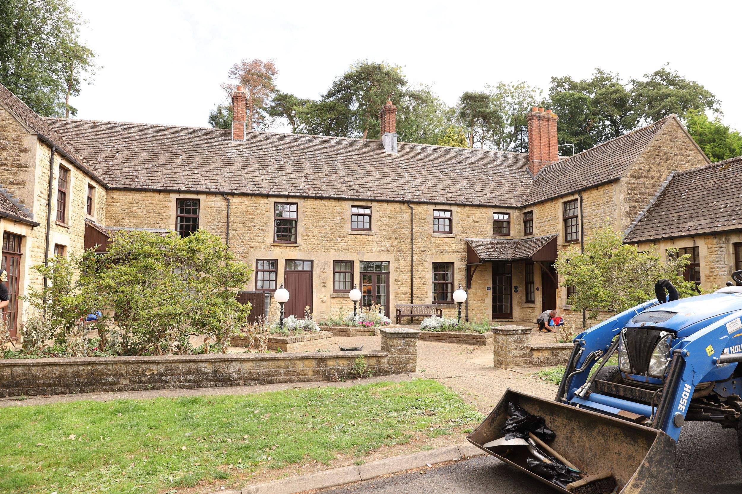 Stone exterior of Rutland Hall Hotel & Spa with landscaped grounds and parked vehicles.