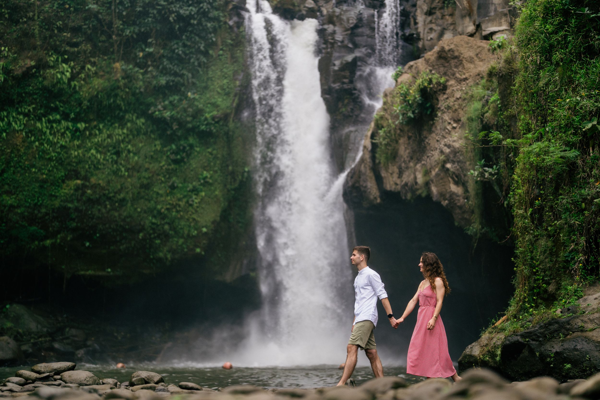 Couple engagement photography with Bali’s iconic Tegenungan Waterfall as the backdrop.