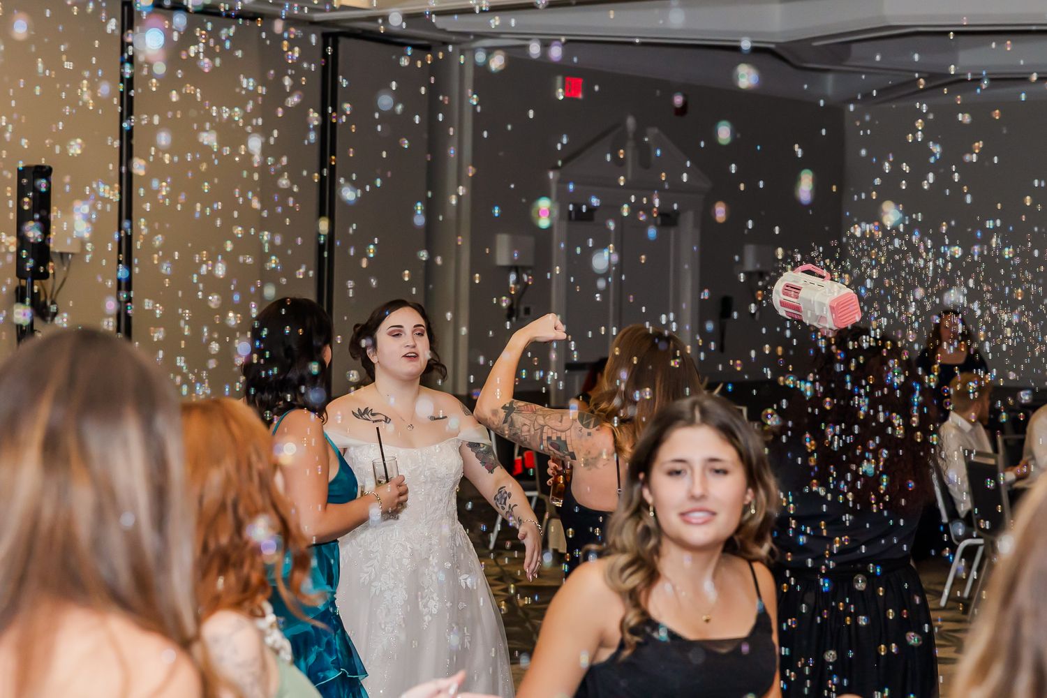 Festive party scene with confetti falling as people dance and celebrate under sparkling lights.