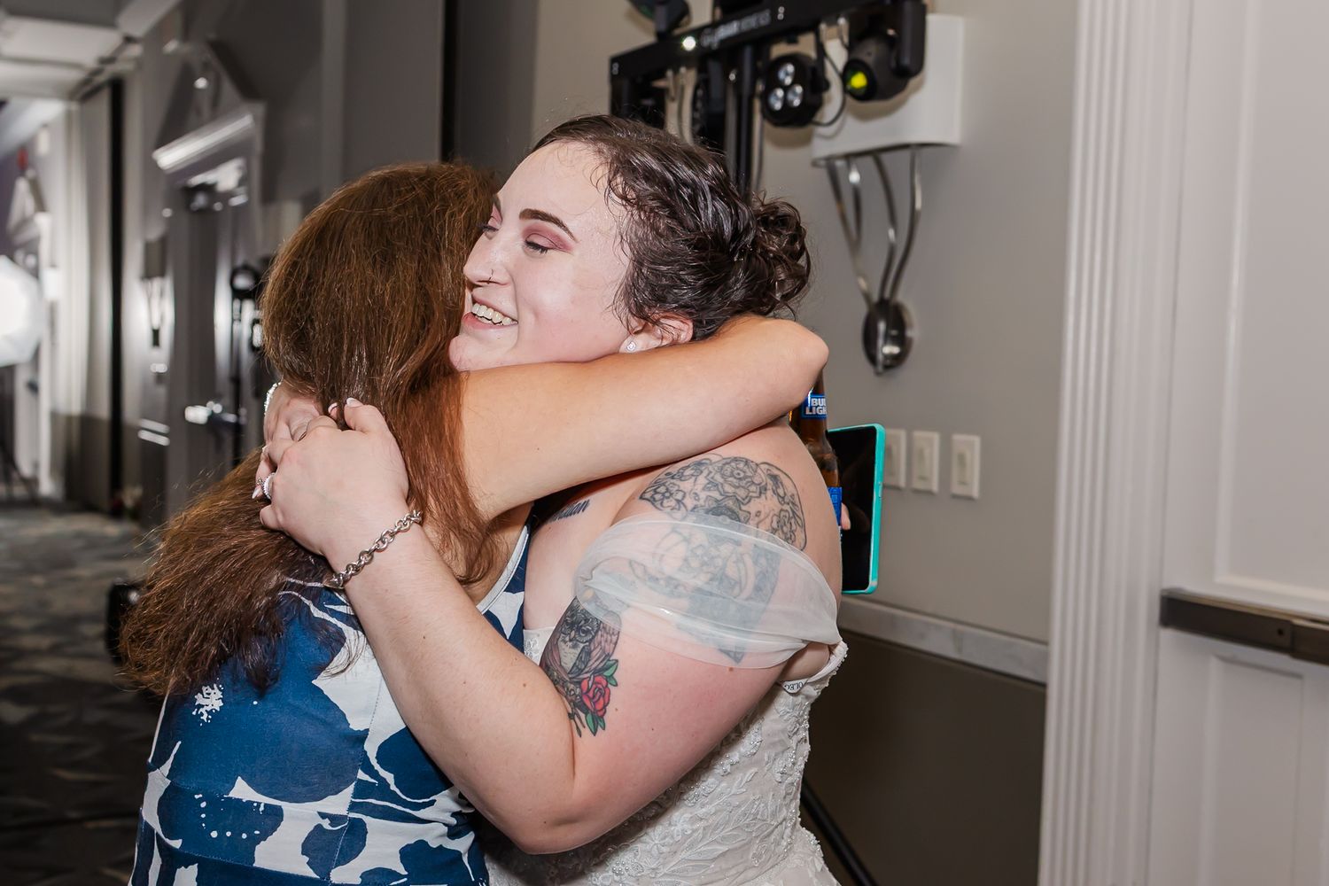 Wedding guests share emotional embraces during a special moment at the reception.