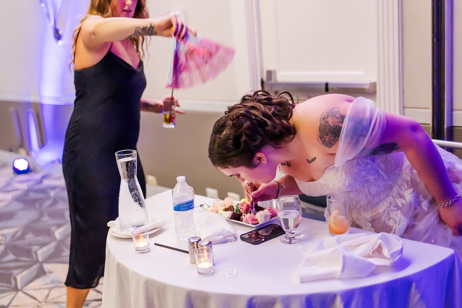 People mingling at an elegant event venue with purple and blue lighting effects.