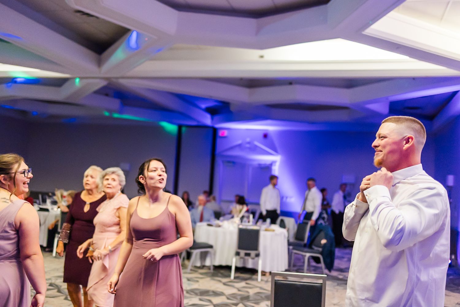 Event space decorated with modern lighting and guests gathered in a contemporary banquet hall setting.