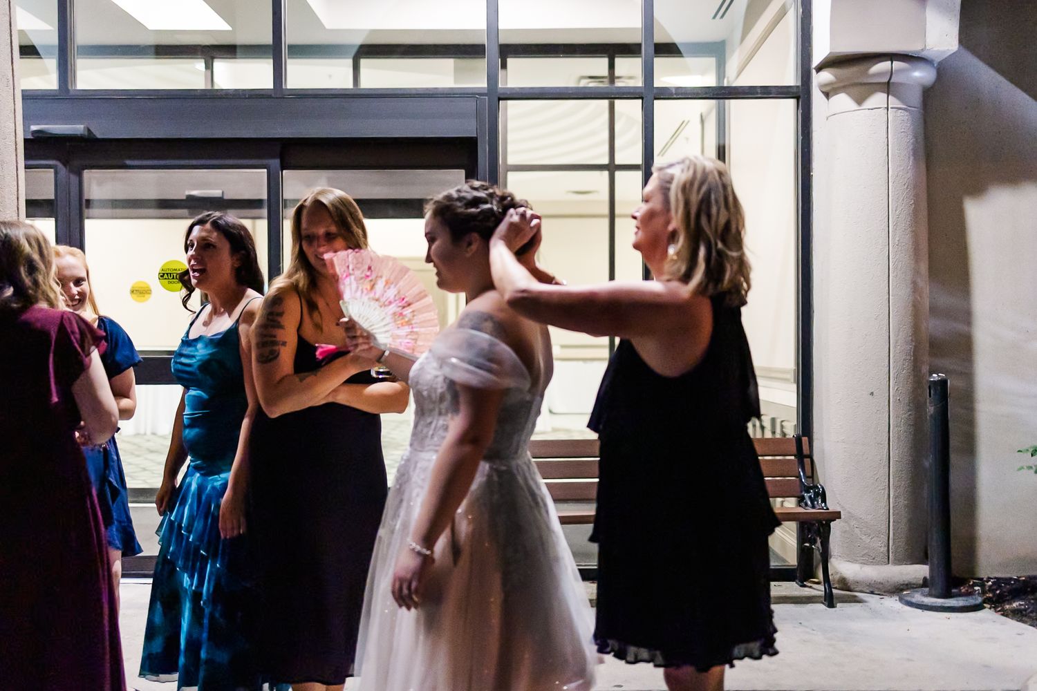 People dancing and celebrating in a bright indoor space with large windows.