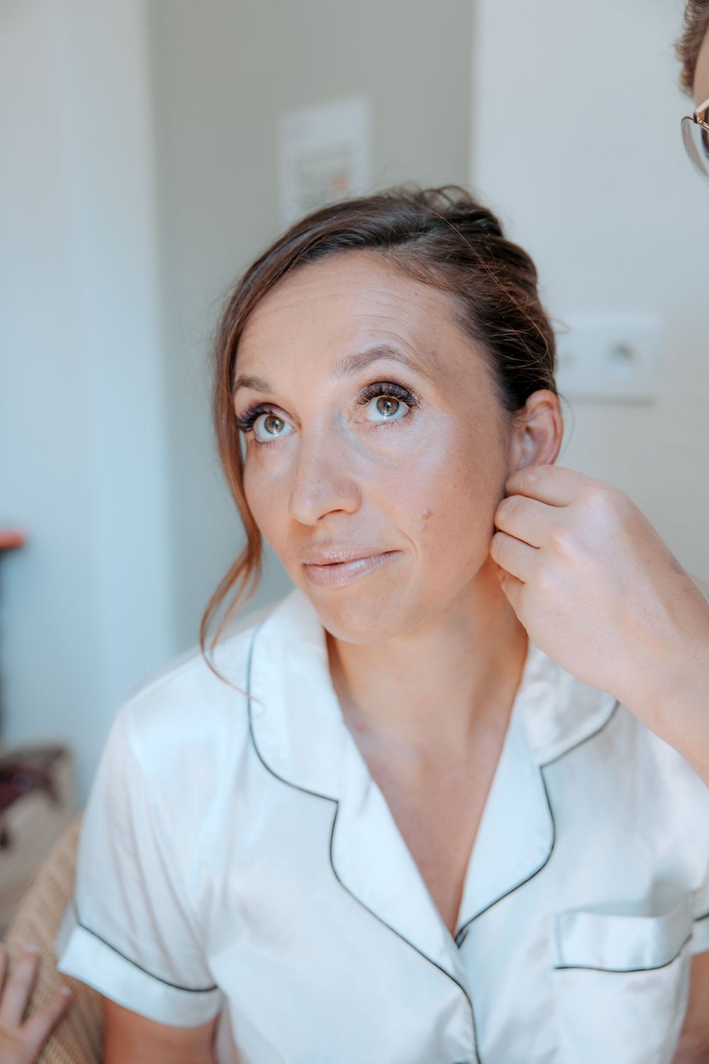 Getting ready sequence showing final touches in a white silk robe. Domaine la Plume photographe mariage