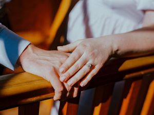 Several close-up shots of hands gently resting on wooden surfaces in warm lighting conditions.