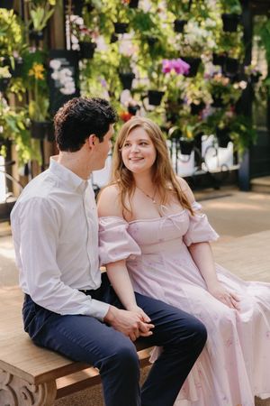 A couple sitting on a bench having a romantic moment together in a garden setting.