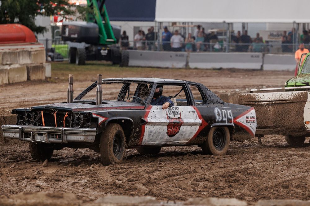 Muddy off-road track with tire ruts and obstacles for vehicle testing or racing courses.